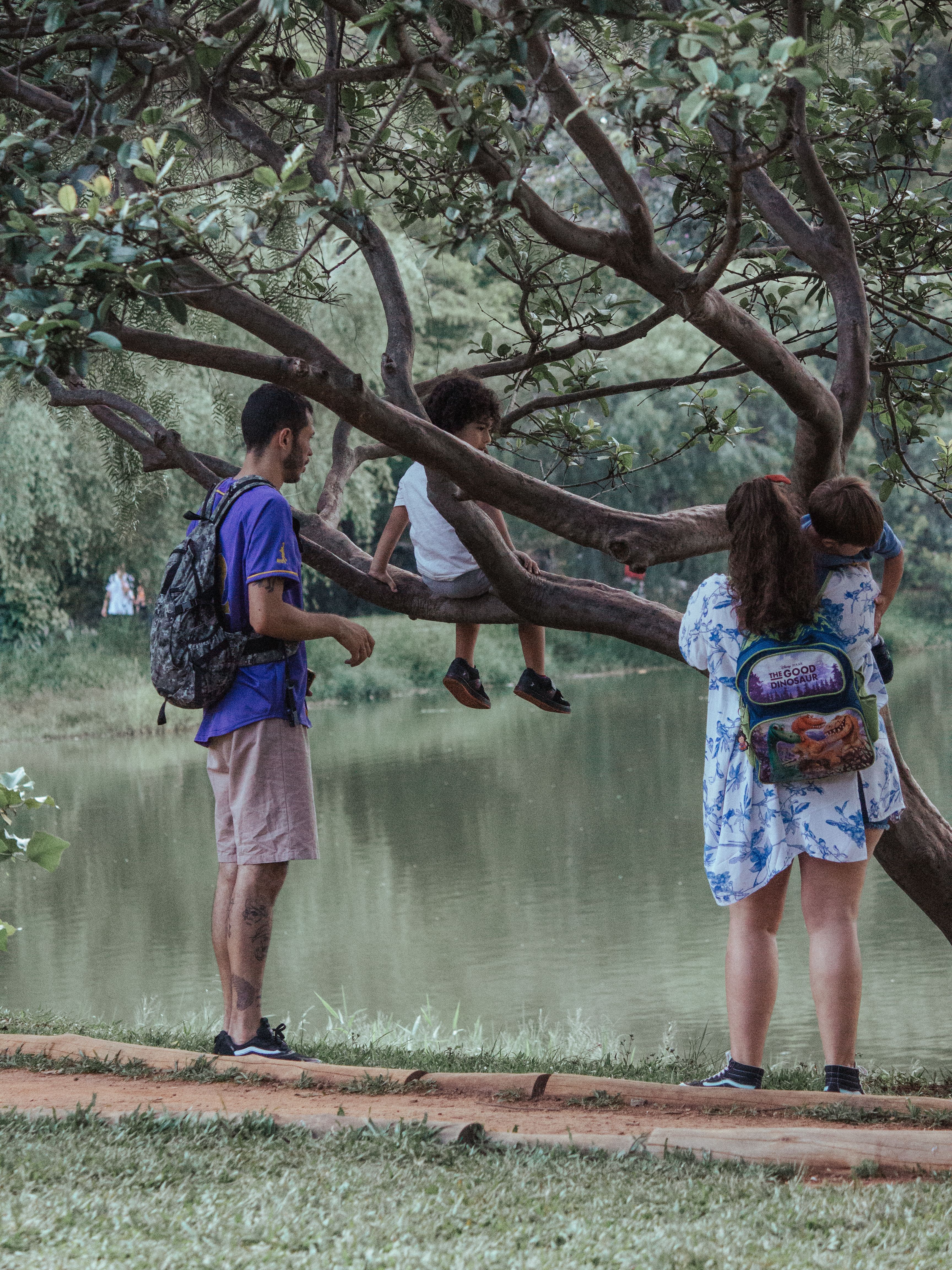 A family spending peaceful moments by a serene lake in a lush park setting.