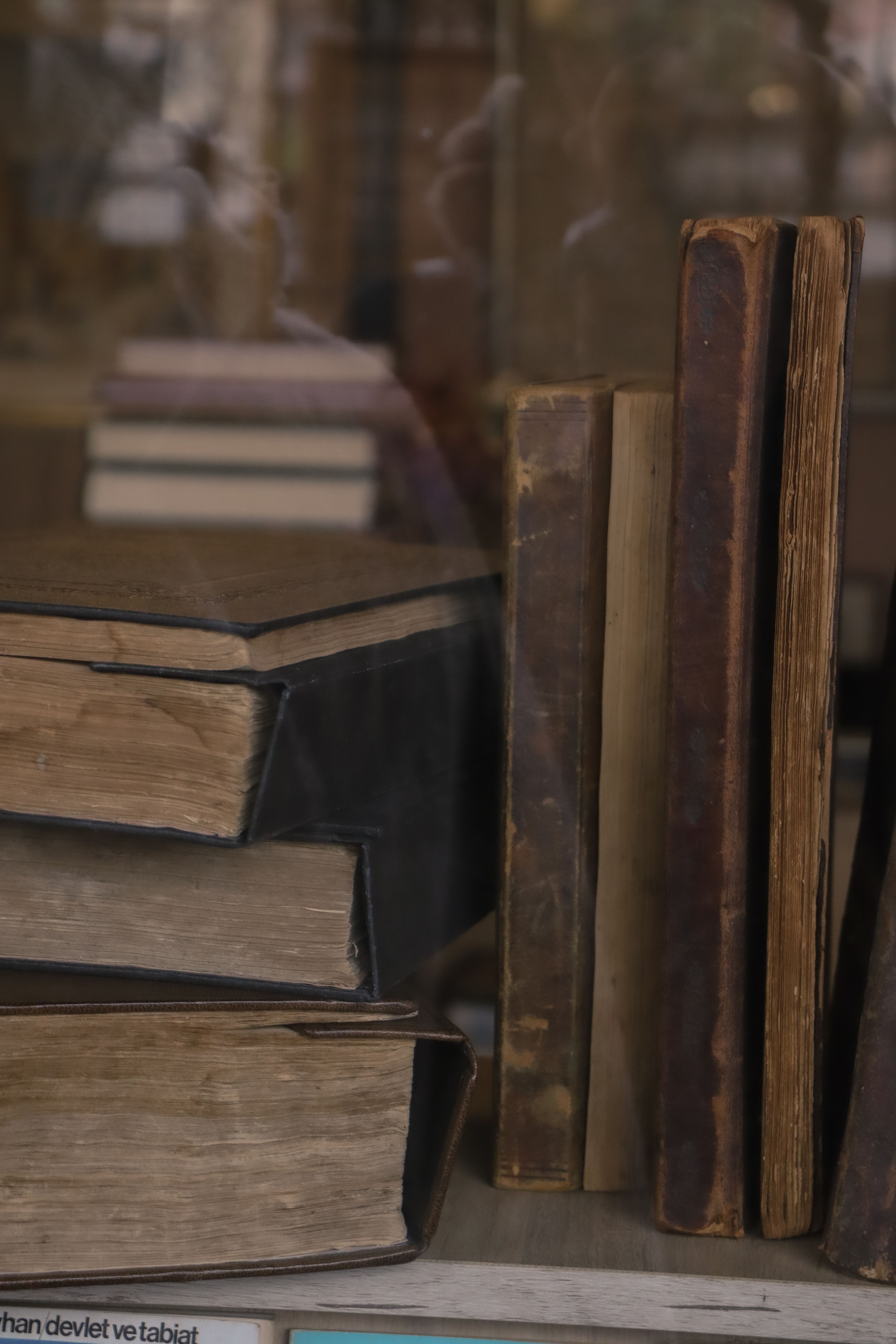 A close-up view of a stack of vintage books on display in an antique shop.