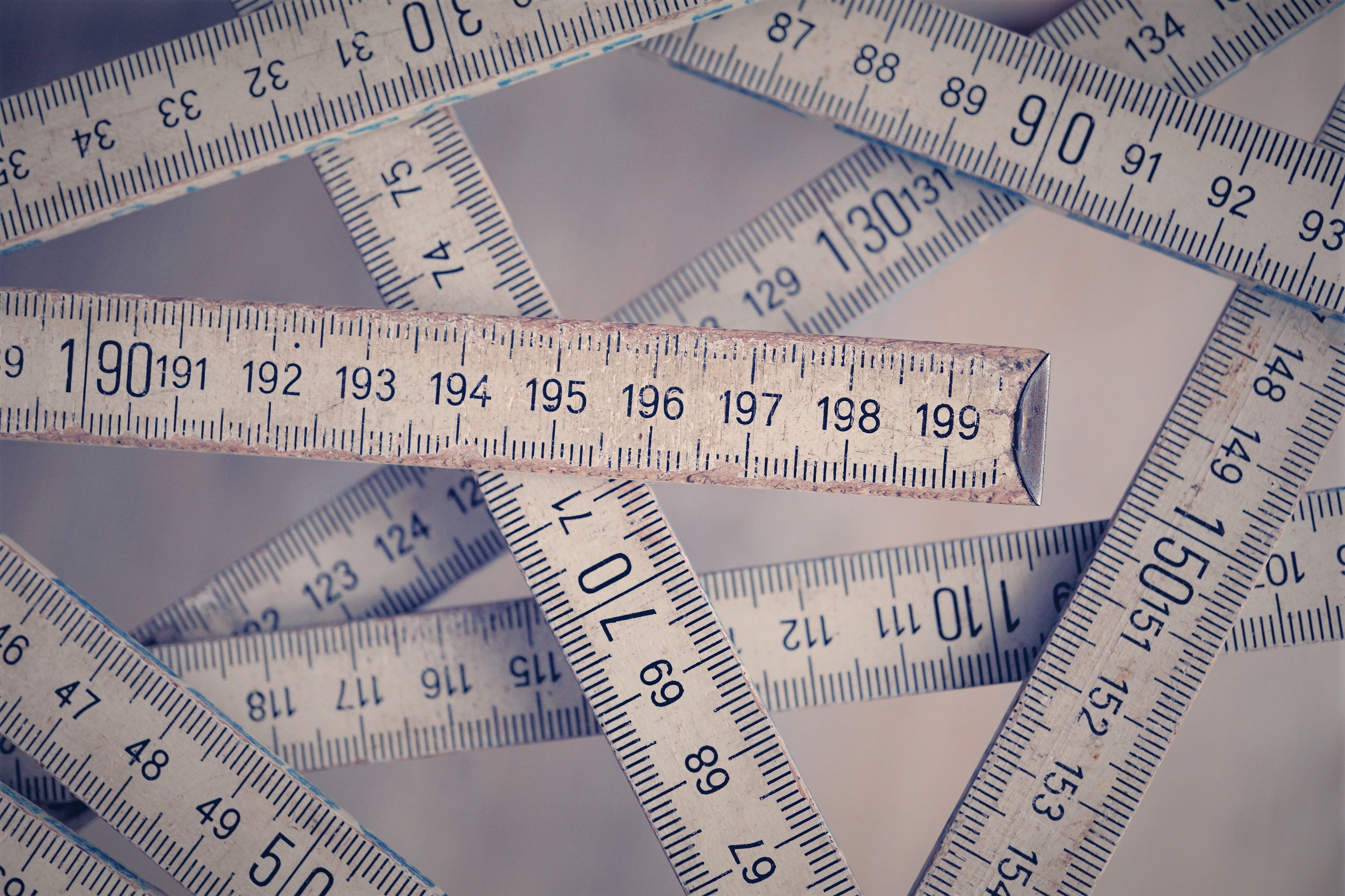A collection of vintage folding rulers measuring in centimeters on a neutral background.