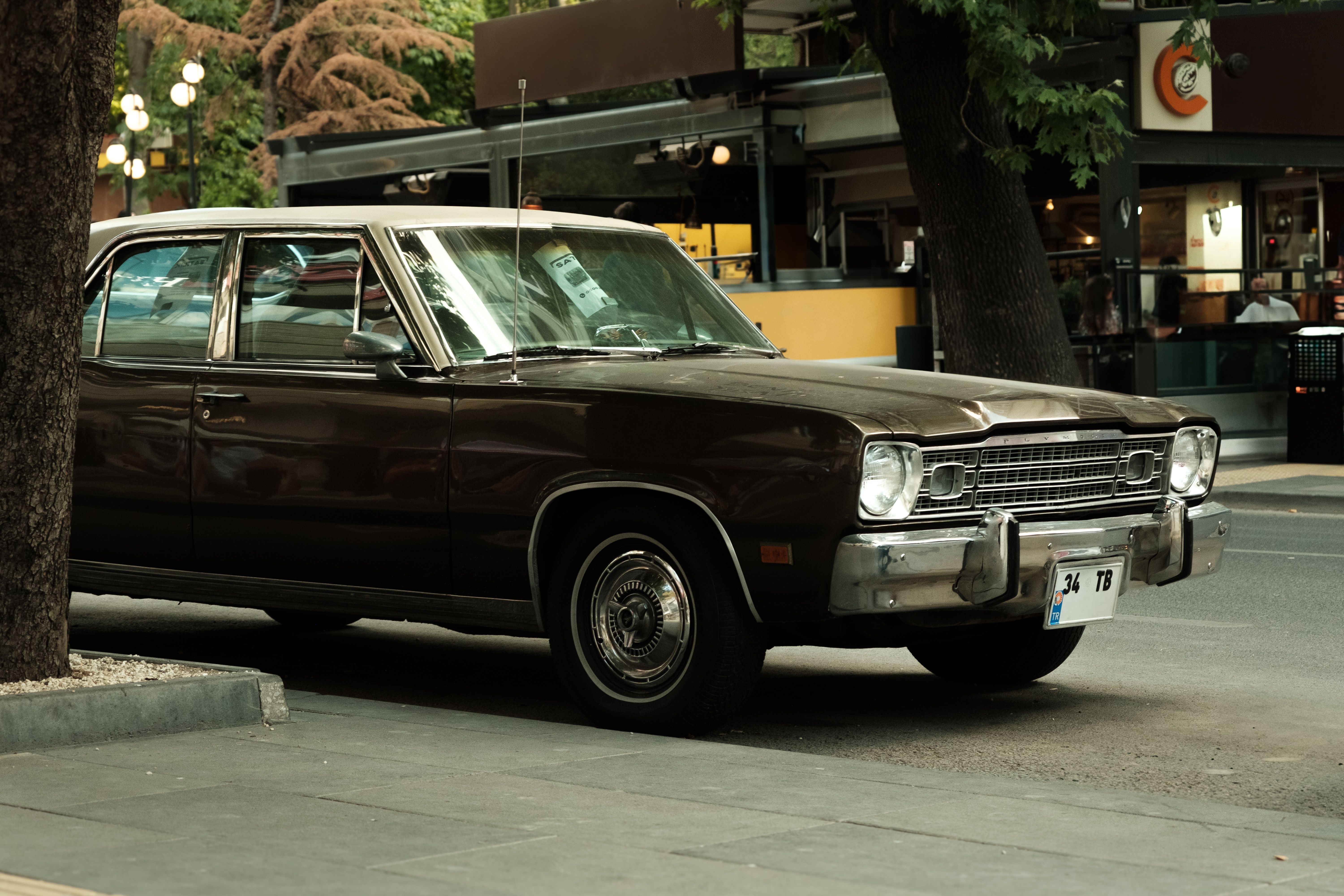 A classic vintage car parked on a city street, evoking nostalgia and urban charm.