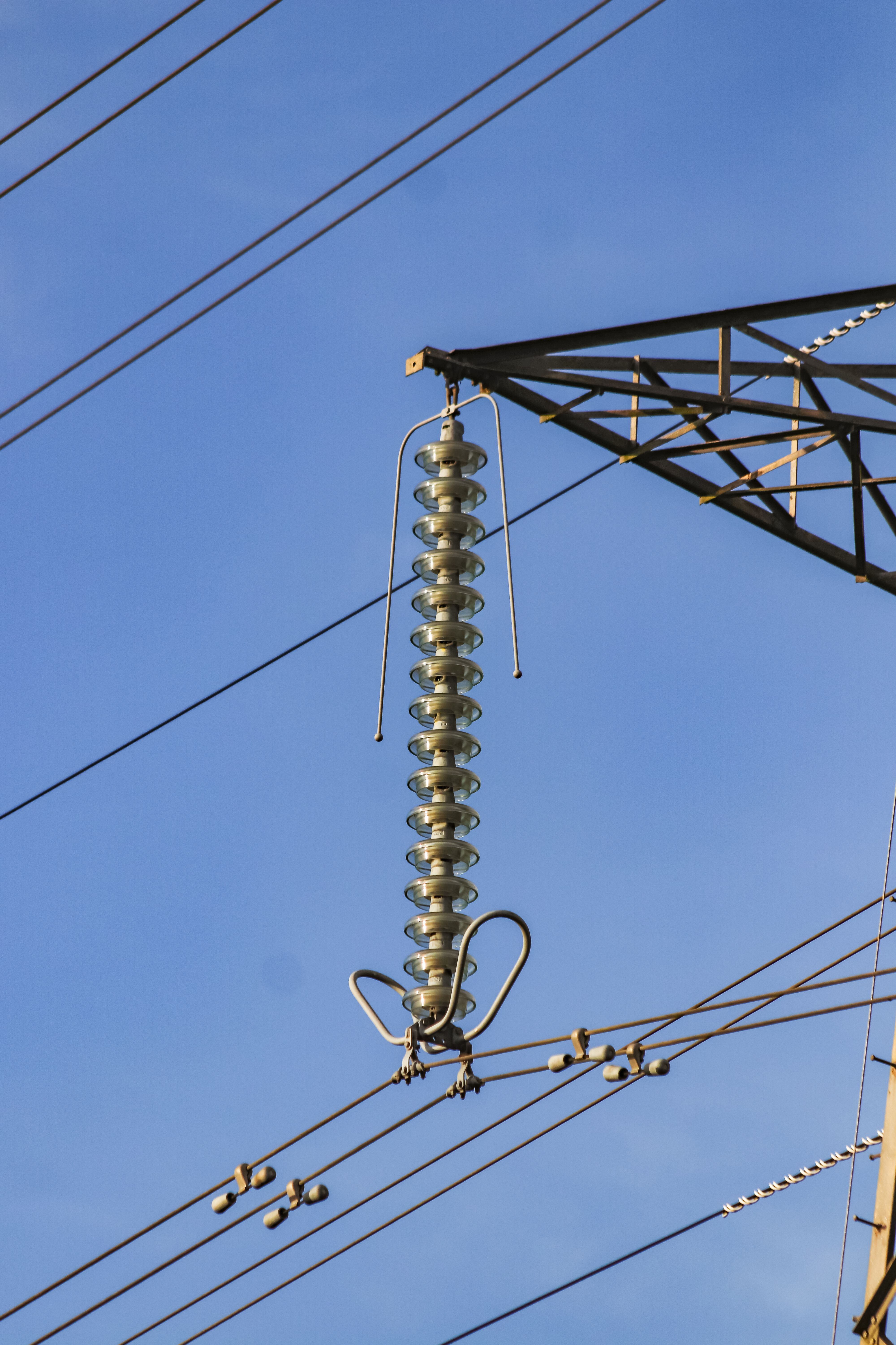 Close-up of insulators and power lines on a transmission tower.