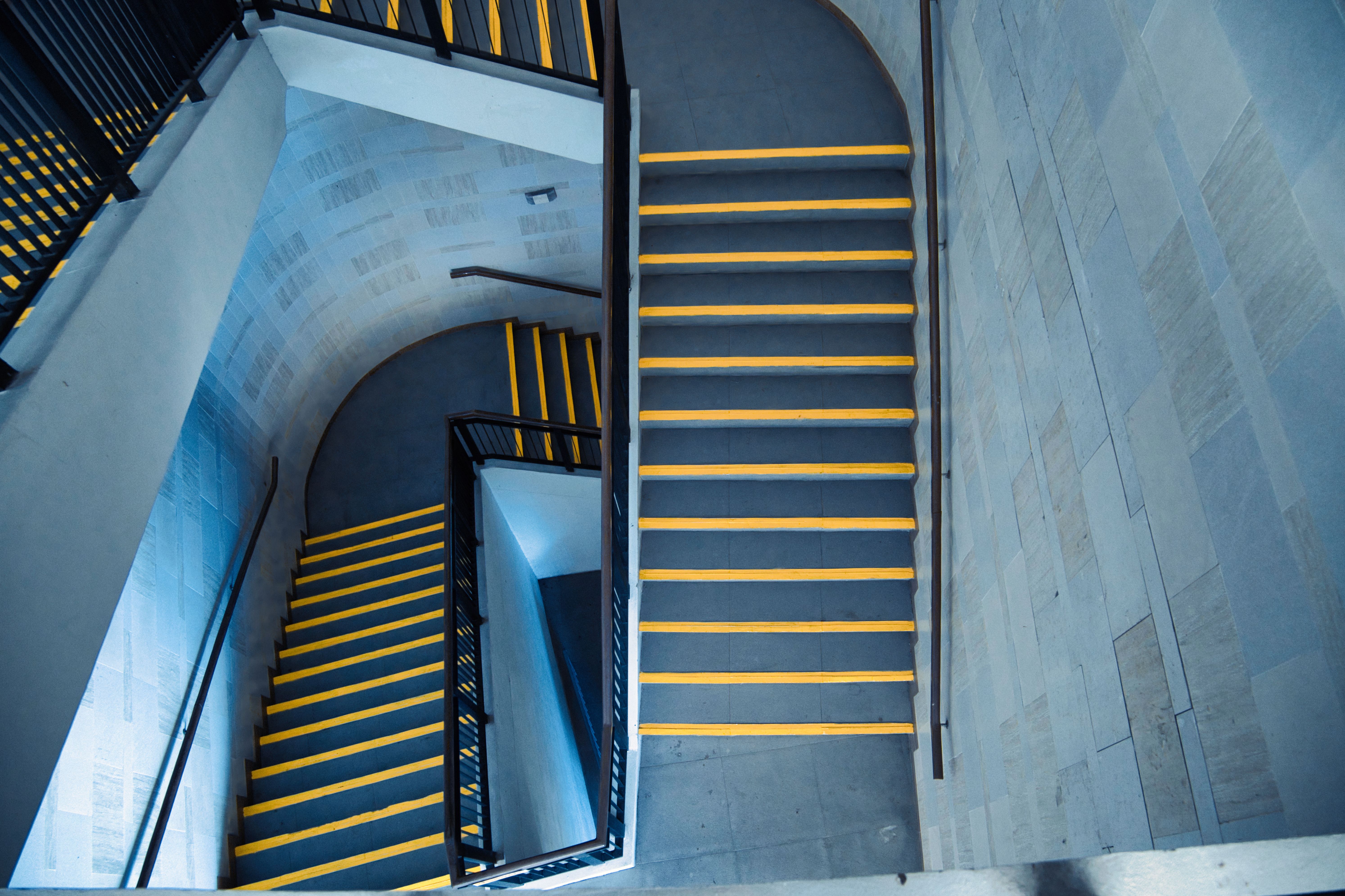 A top-down view of a modern stairway with striking yellow highlights indoors.