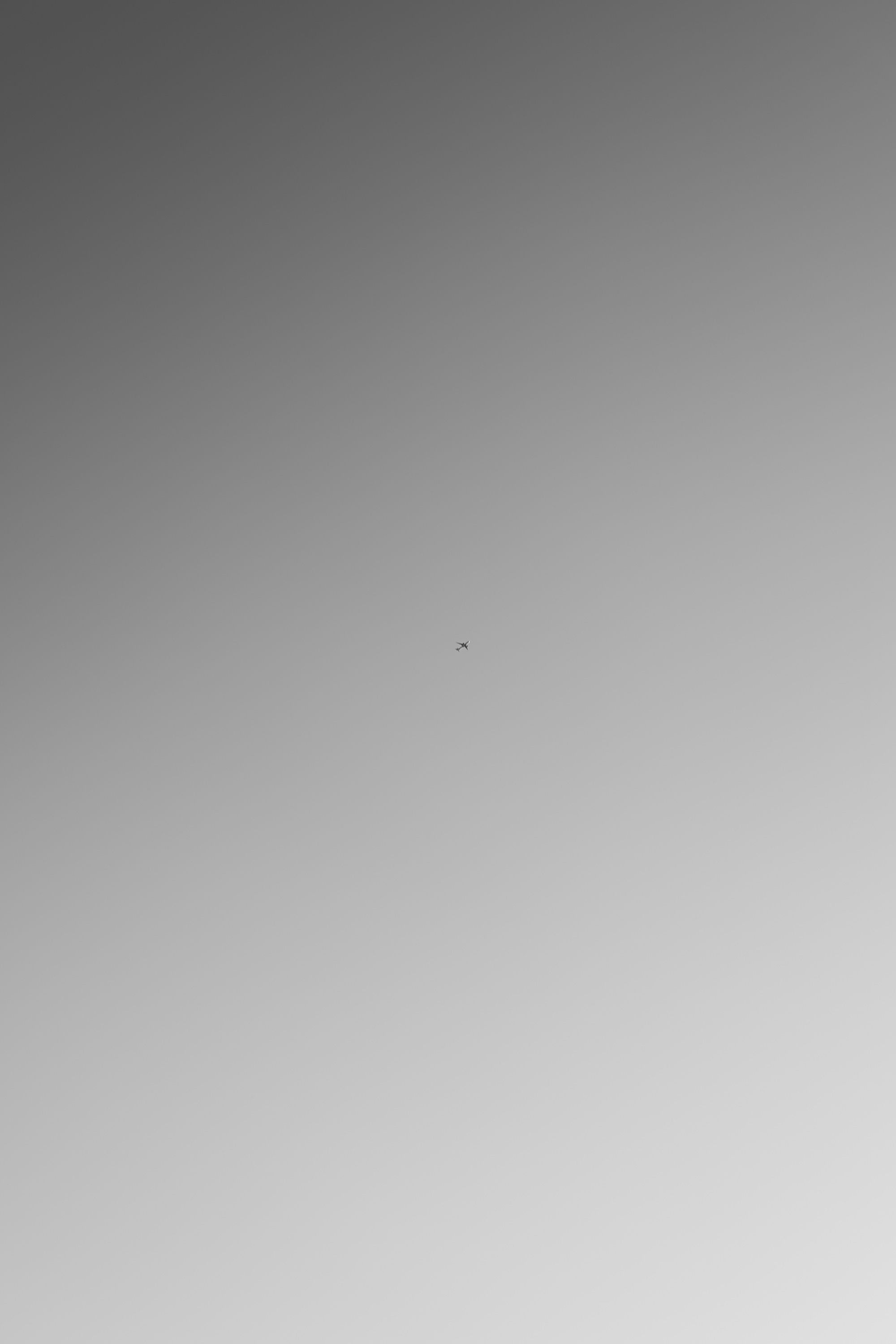 A small airplane captured in a minimalist scene with a clear blue sky, conveying a sense of freedom.