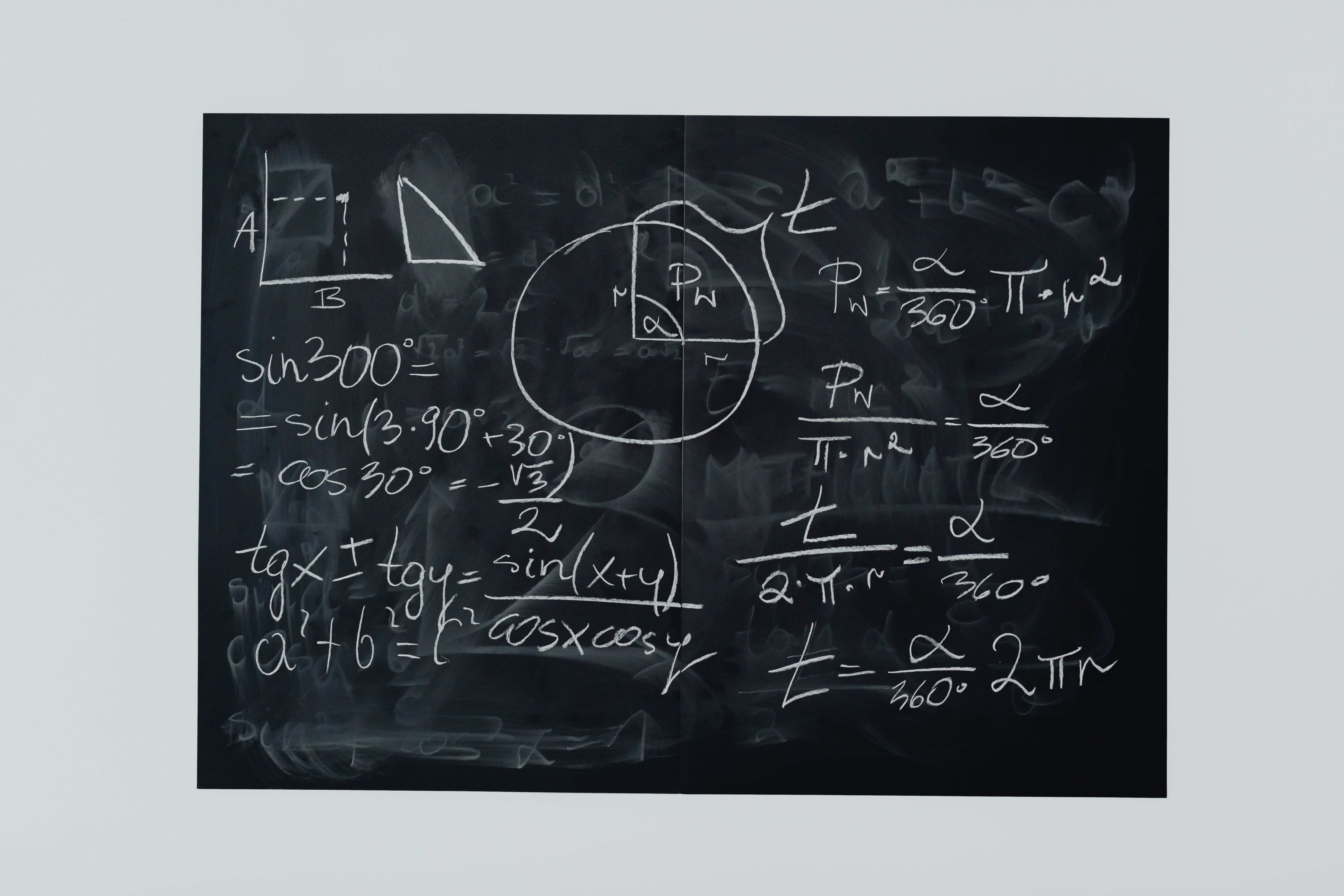 Detailed view of mathematical equations and diagrams on a blackboard.