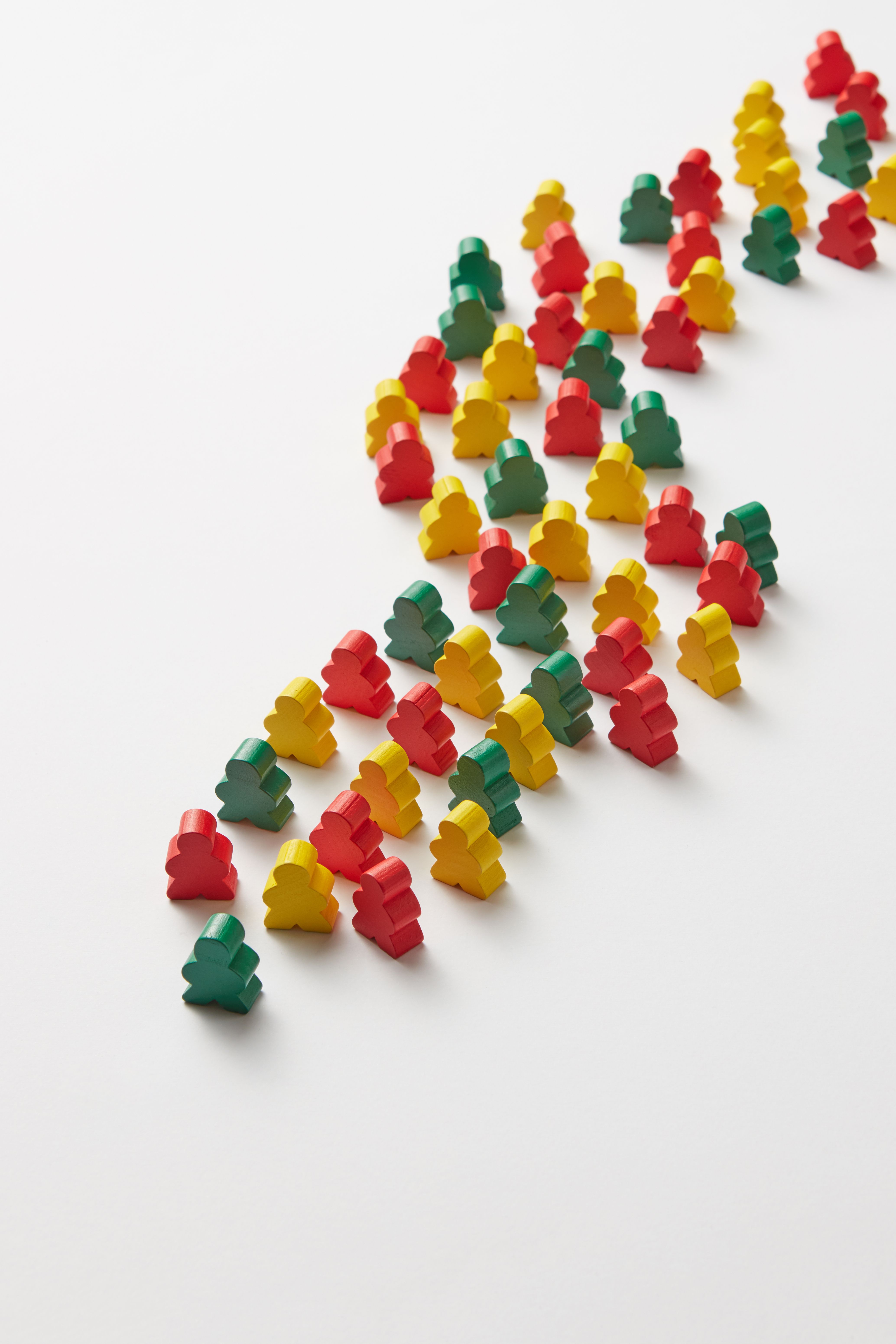 Top view of colorful wooden toy blocks arranged on a white background in a curved pattern.